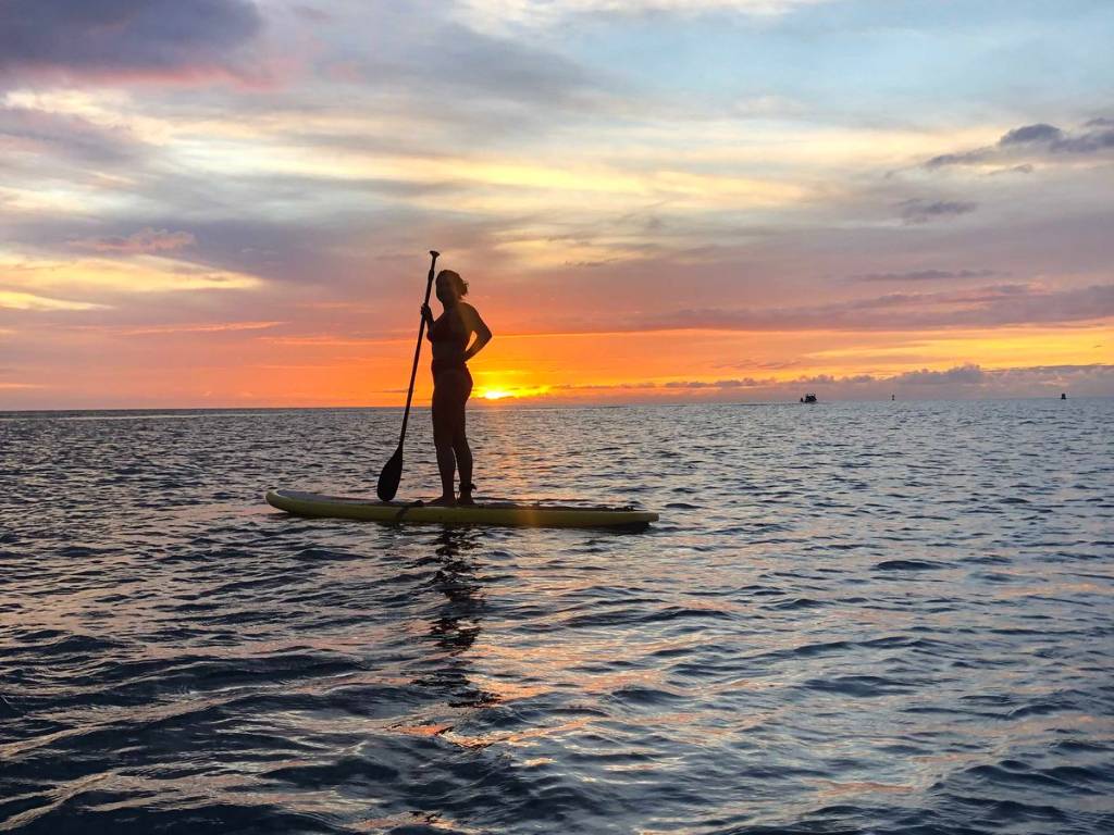 Surfer paddling out at golden hour Sunset Beach North Shore Oahu