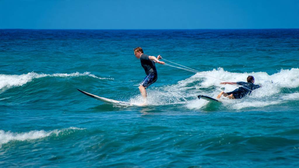 surfer inside versus back paddler trying to sneak the wave at beach break