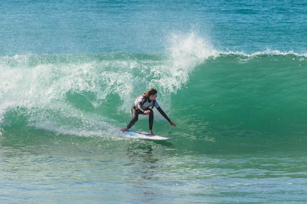 Surfer angling takeoff on green wave face