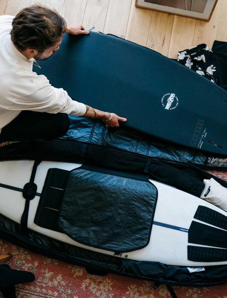 Surfboard fins neatly organized inside a protective fin bag on a beach