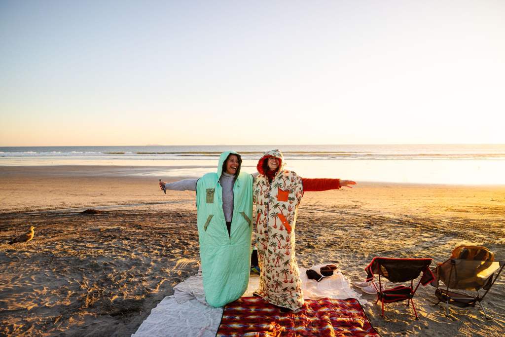 Two women wearing surf ponchos