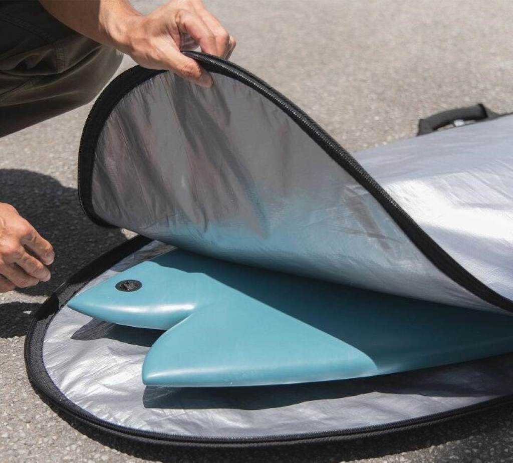 Ventilated surf fin bag with fins drying in sunlight near the ocean
