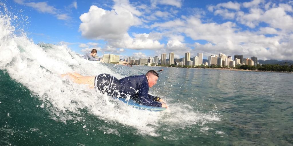 Surfer training with a bodyboard on small Hawaiian waves for learning wave control