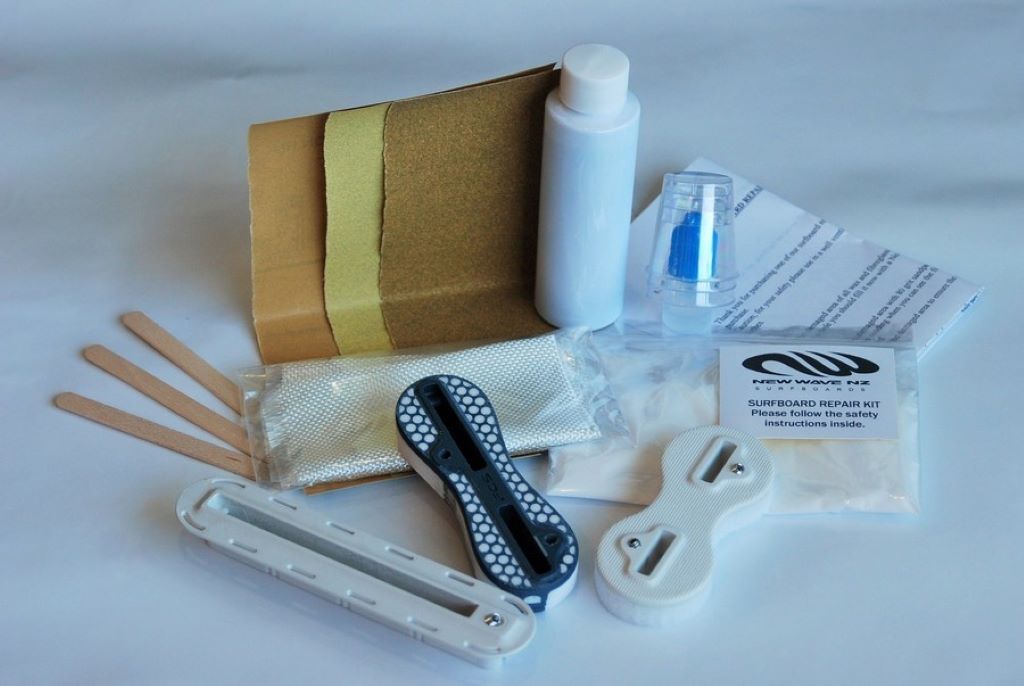 Close-up of surfboard repair tools and resin kit used for DIY board maintenance