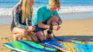 Pair of colorful Wavestorm bodyboards resting on ocean sand dunes