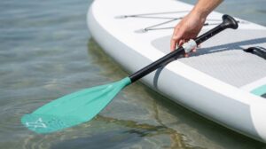 ZLX adjustable SUP paddle lying across inflatable paddle board deck